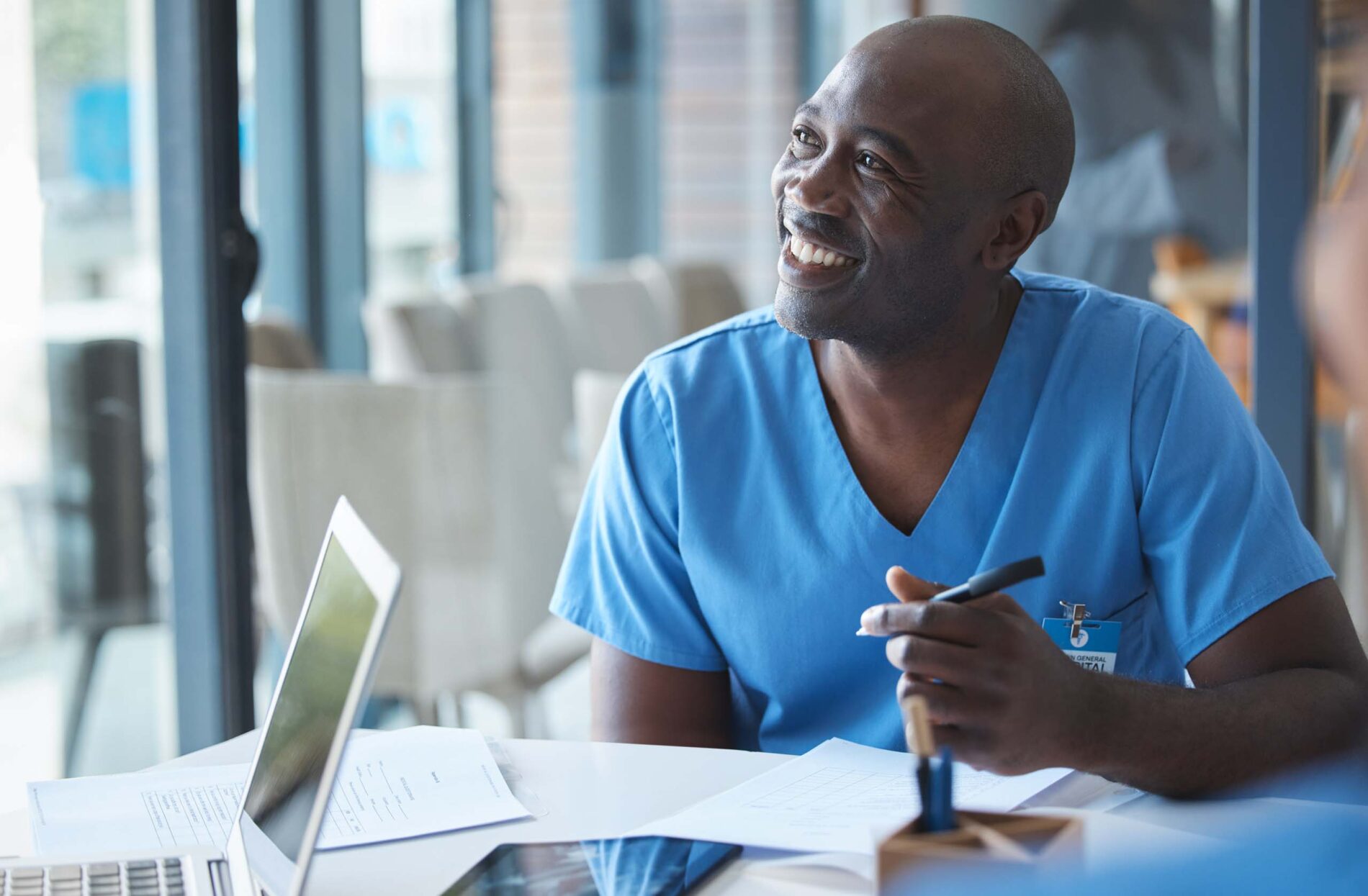 smiling male nurse sitting at desk