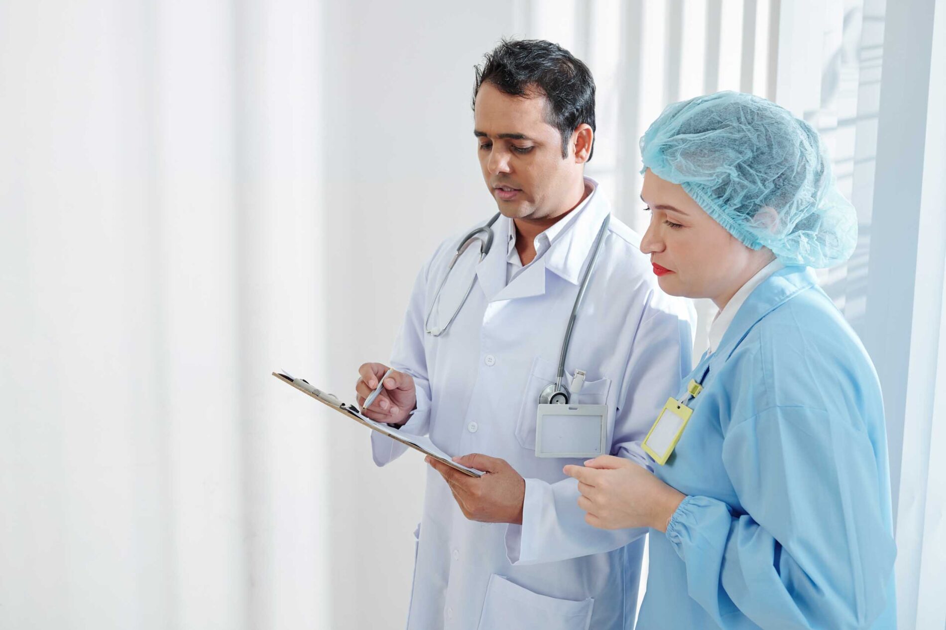surgeon and physician reviewing notes on a clipboard