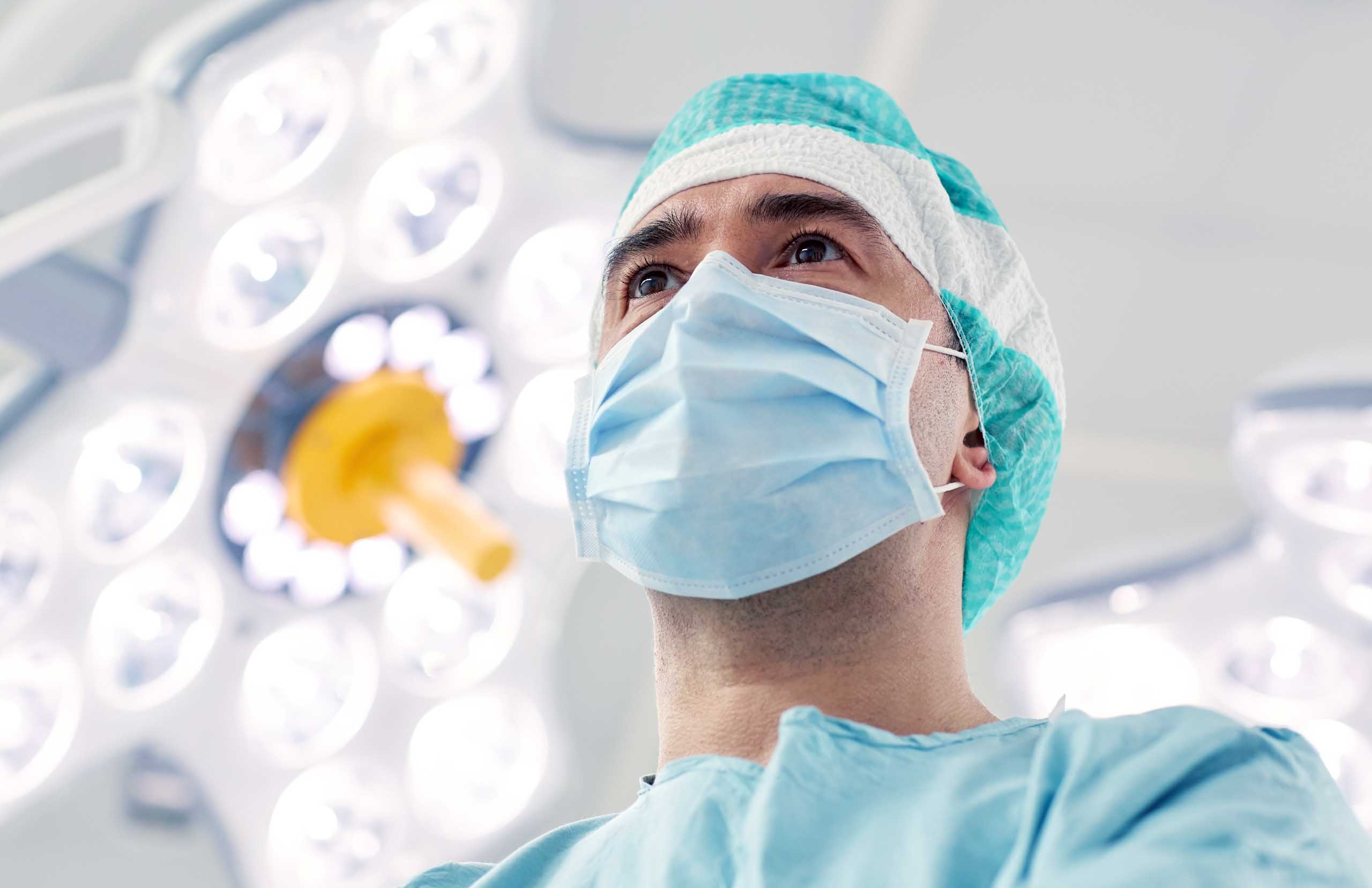 male surgeon in an operating room with bright lights